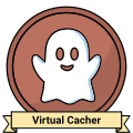 A stylized metalic badge. It appears to be made of bronze and features a cartoony white ghost. A ribbon reading Virtual Cacher sits on the bottom.